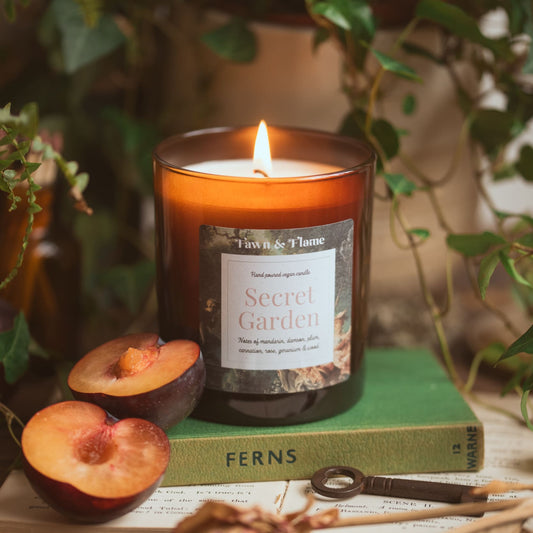 Secret Garden vegan candle with plum, roses and ivy, and books.