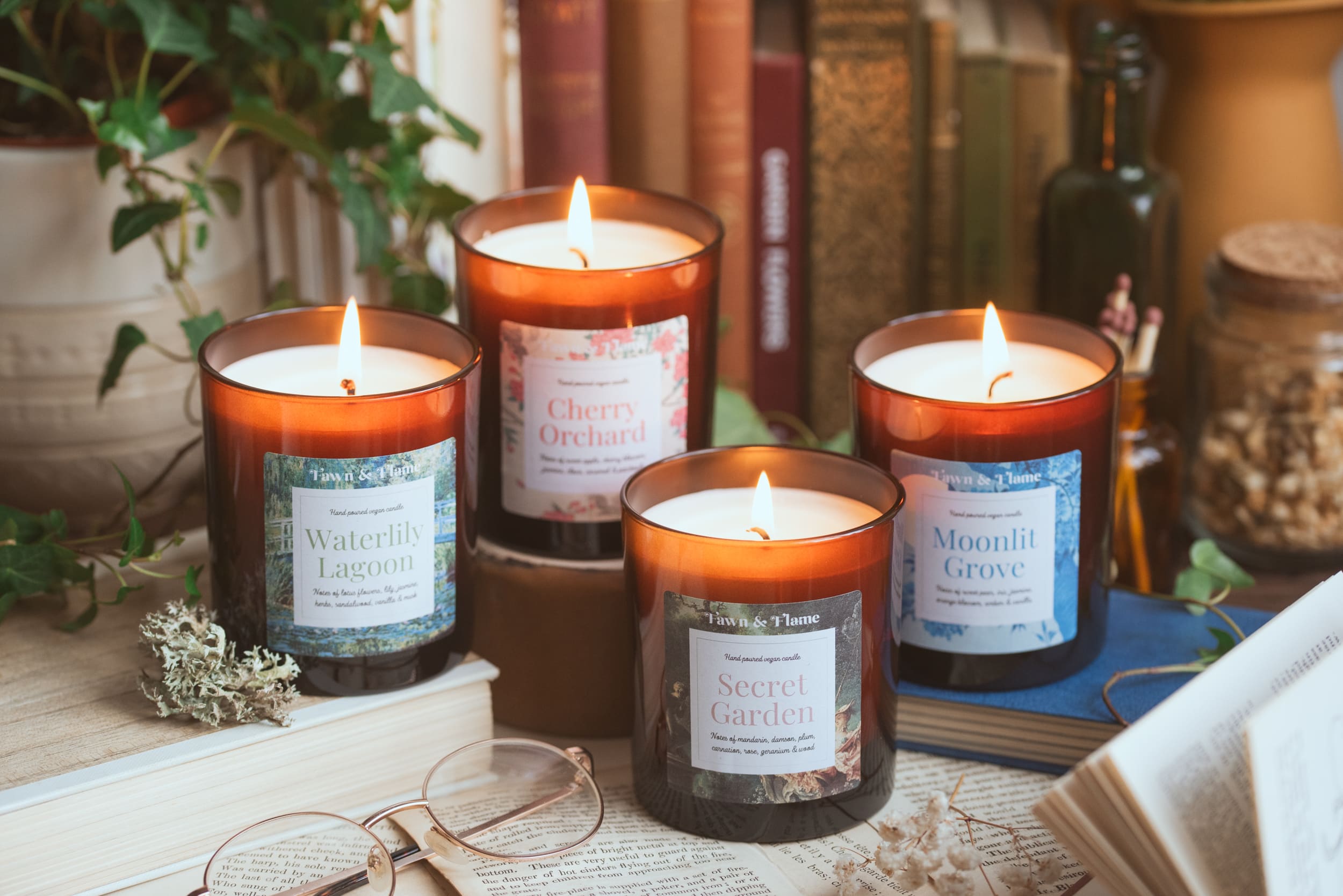 fawn and flame vegan candles surrounded by books and botanicals.