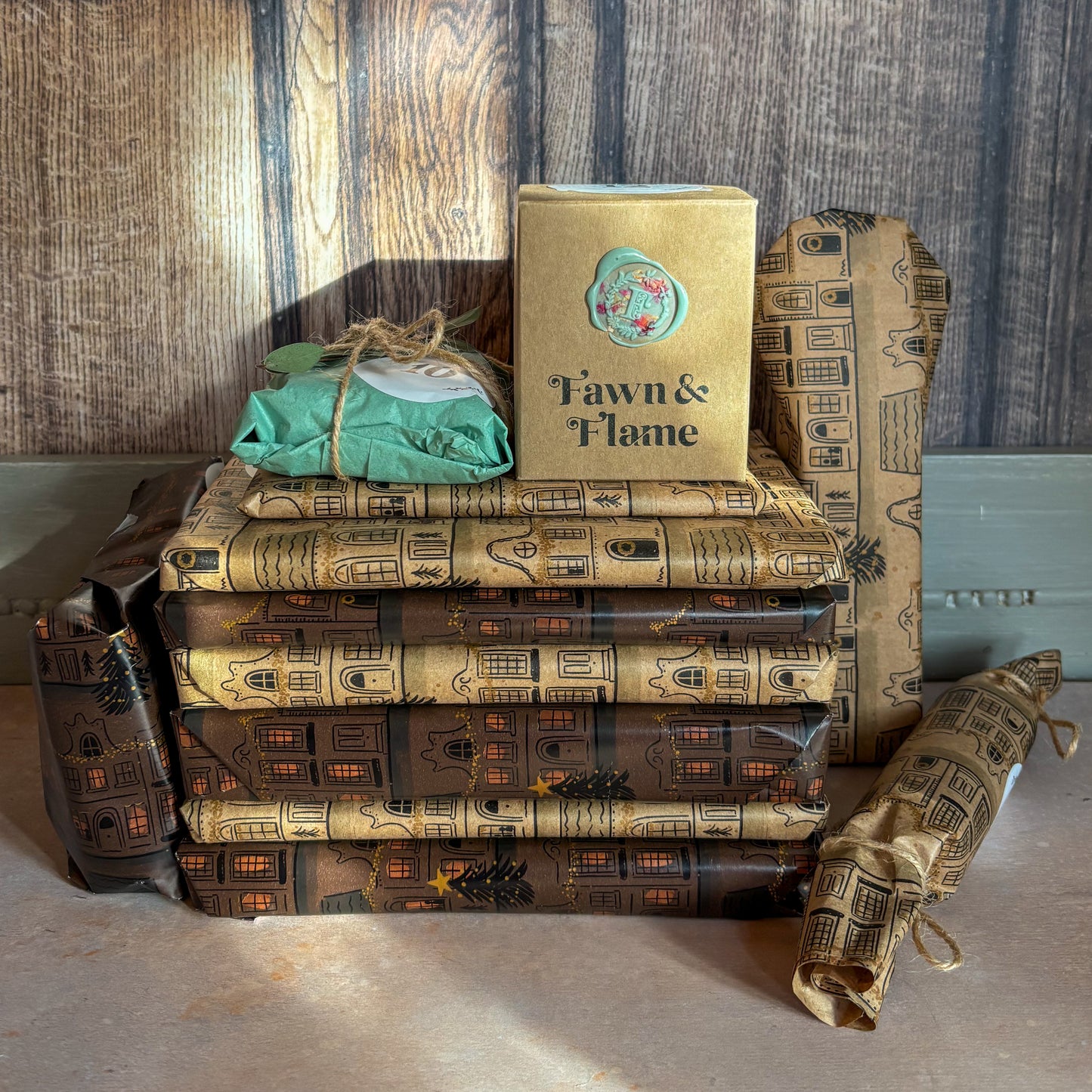 Stack of books wrapped in patterned paper with a visible brand name on a wooden surface.