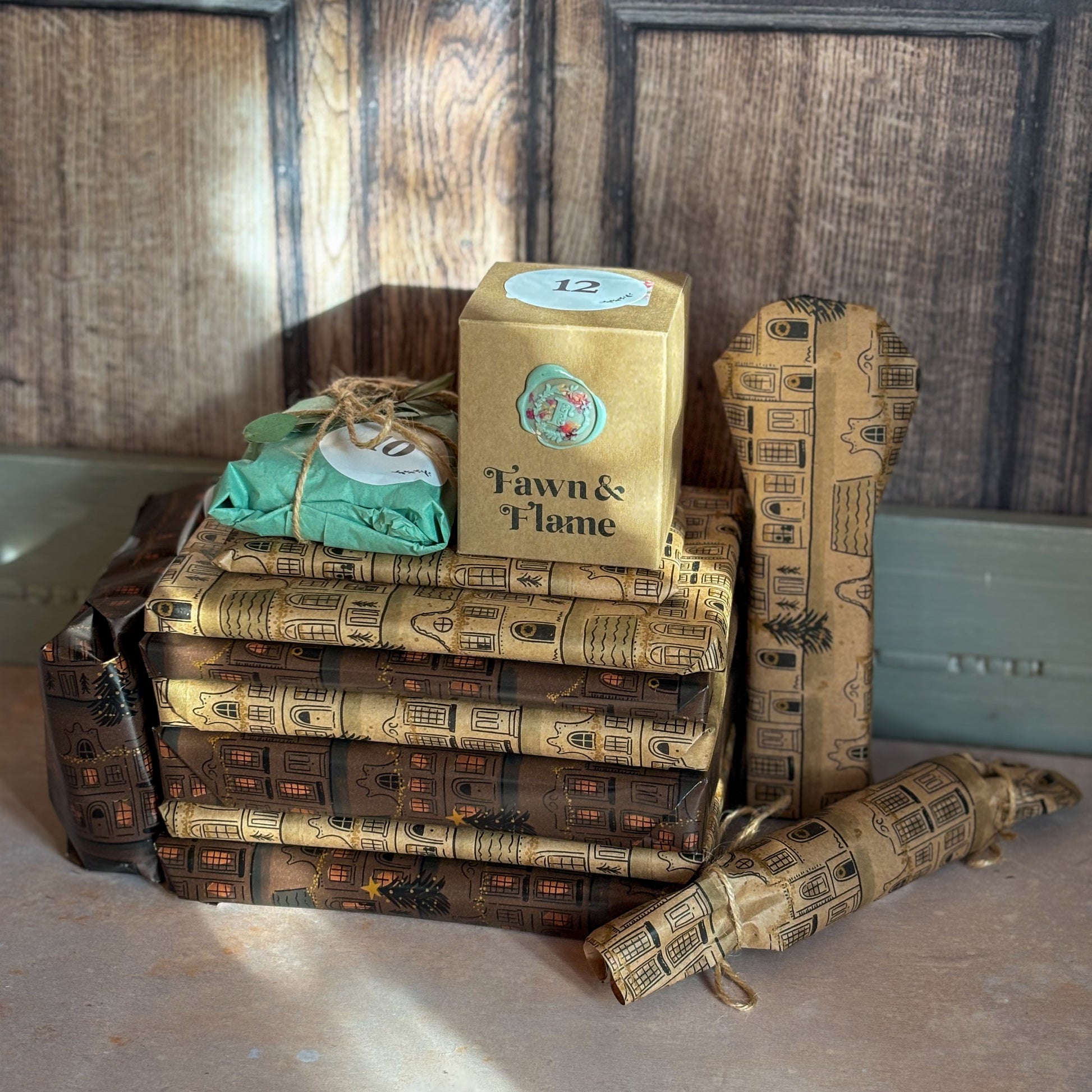 Stack of books with decorative covers and a box labeled 'Tawn & Flame' on a wooden surface.