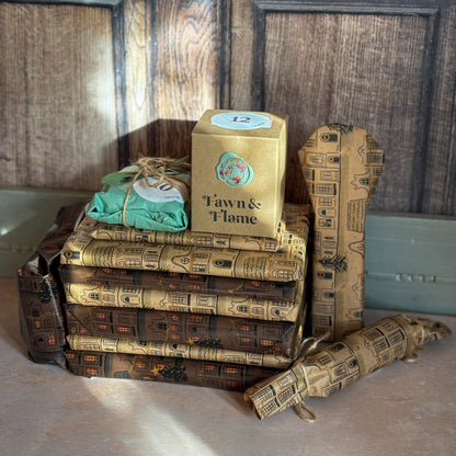 Stack of books with decorative covers and a box labeled 'Tawn & Flame' on a wooden surface.