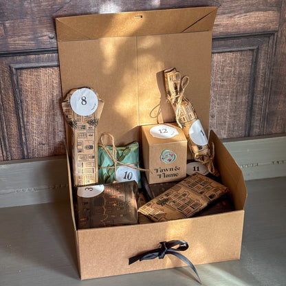 Gift set with candles and packaging in a cardboard box on a wooden floor.