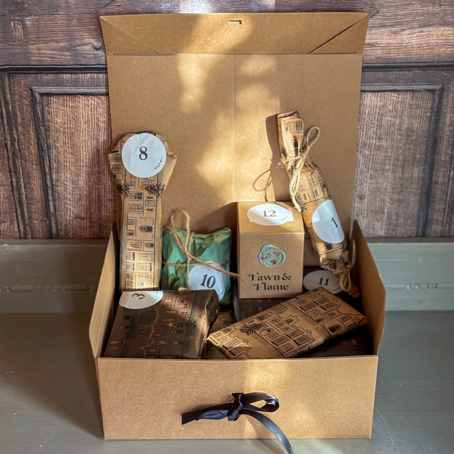 Gift box with numbered items and a bottle, against a wooden background