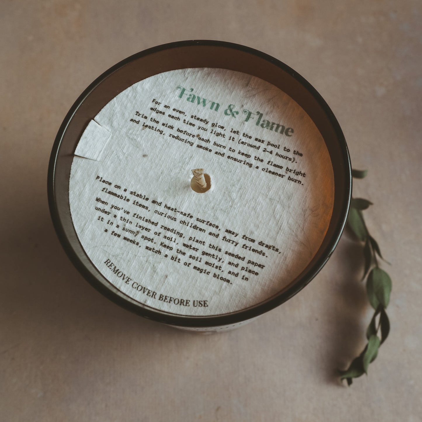 Seeded paper candle dust cover with Fawn & Flame candle care description and planting instructions.